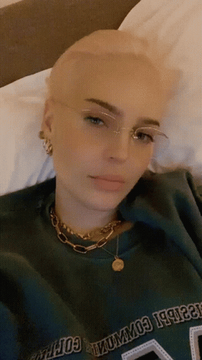 A Woman With Glasses And A Green Shirt That Says Columbia GIF