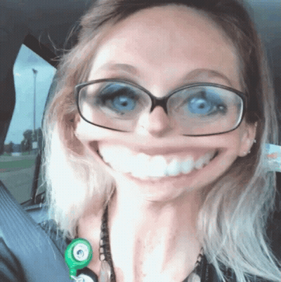 A Woman With Glasses And A Stethoscope Around Her Neck Smiles For The Camera GIF