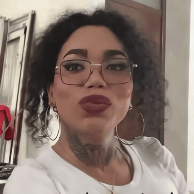 A Woman With Glasses And A Tattoo On Her Neck Is Wearing A White Shirt That Says I Love You GIF