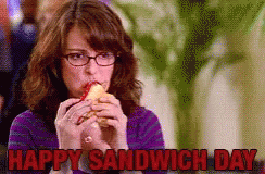 A Woman With Glasses Is Eating A Sandwich With The Words Happy Sandwich Day Above Her GIF
