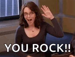 A Woman With Glasses Is Waving Her Hand And Saying `` You Rock '' . GIF