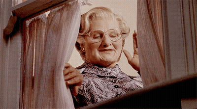 A Woman With Glasses Looks Out A Window GIF