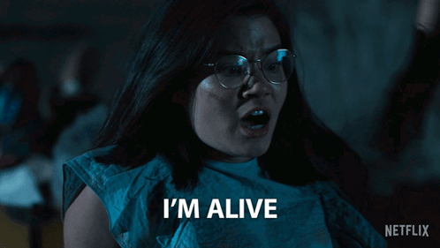 A Woman With Glasses Says I 'M Alive In Front Of A Netflix Logo GIF