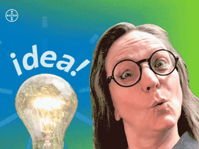 A Woman With Glasses Stands In Front Of A Light Bulb That Says Idea On It GIF