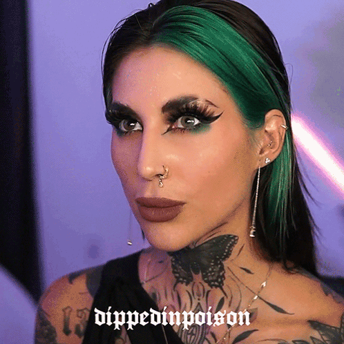 A Woman With Green Hair Has The Words Dipped In Poison Written On Her Face GIF