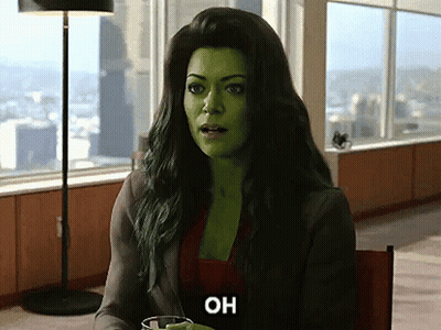 A Woman With Green Hair Is Sitting At A Table With A Glass Of Water And The Word Oh On Her Face . GIF