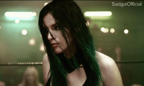 A Woman With Green Hair Is Standing In A Ring . GIF
