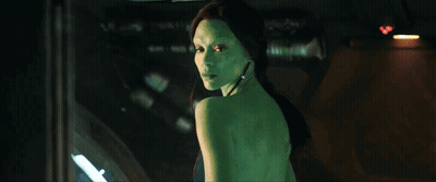 A Woman With Green Hair Is Standing In Front Of A Window GIF