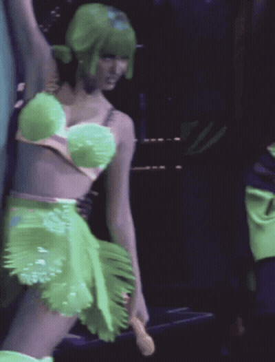 A Woman With Green Hair Is Wearing A Green Dress GIF