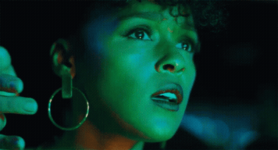 A Woman With Green Paint On Her Face Is Looking Up GIF