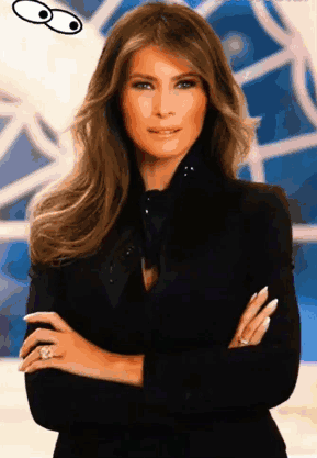 A Woman With Her Arms Crossed Is Wearing A Black Jacket And A Ring GIF