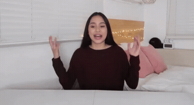 A Woman With Her Arms Outstretched And The Words I 'M Back GIF