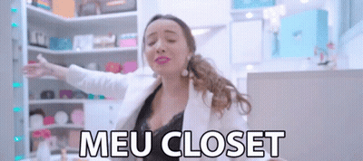 A Woman With Her Arms Outstretched In Front Of A Closet That Says Meu Closet On It GIF