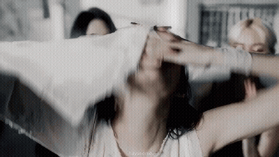 A Woman With Her Arms Outstretched Is Holding A White Cloth Over Her Head . GIF