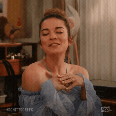 A Woman With Her Eyes Closed And The Word Schittscreek Written On The Bottom GIF