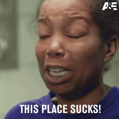 A Woman With Her Eyes Closed And The Words This Place Sucks On The Bottom GIF