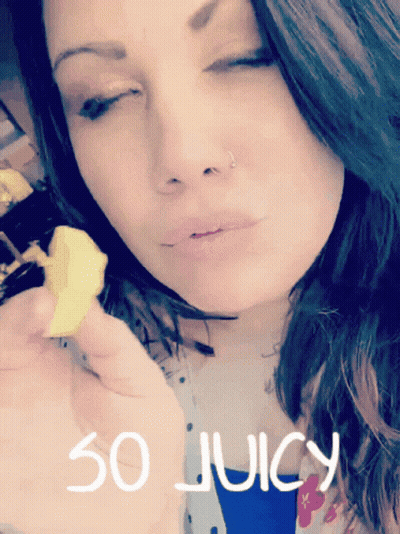 A Woman With Her Eyes Closed Is Holding A Piece Of Food With The Words So Juicy Written On The Bottom GIF