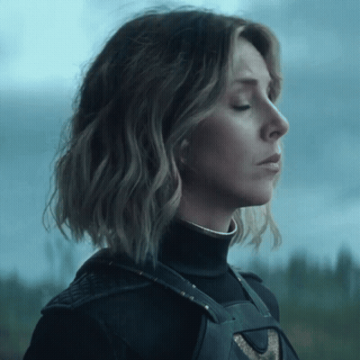 A Woman With Her Eyes Closed Is Wearing A Black Top GIF
