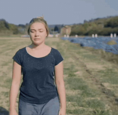 A Woman With Her Eyes Closed Standing In A Field GIF