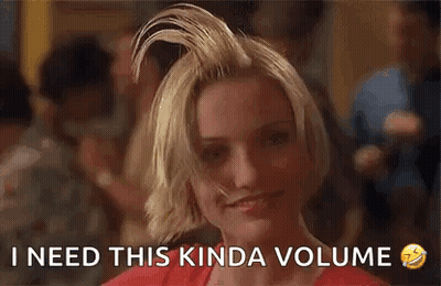 A Woman With Her Hair In A Bun Is Smiling And Says `` I Need This Kinda Volume '' . GIF