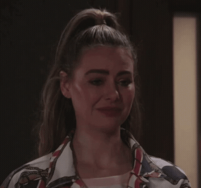 A Woman With Her Hair In A Ponytail Is Making A Sad Face GIF