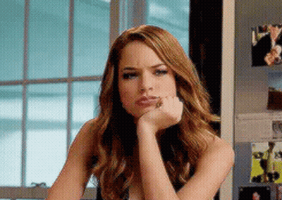 A Woman With Her Hand On Her Chin Is Sitting In Front Of A Window . GIF