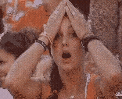 A Woman With Her Hands On Her Head Is Wearing A Necklace With A Cross On It GIF