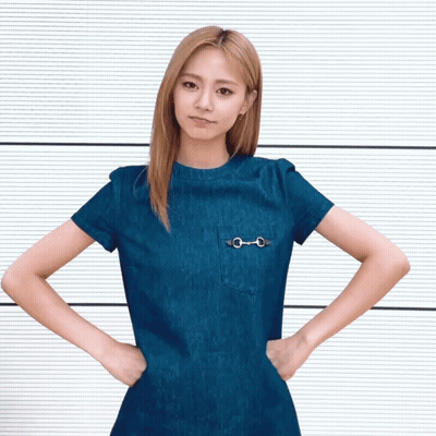 A Woman With Her Hands On Her Hips Wears A Blue Shirt GIF