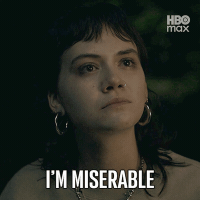 A Woman With Hoop Earrings Says I 'M Miserable In Front Of A Hbo Max Logo GIF