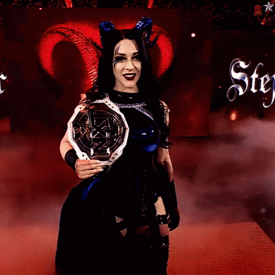 A Woman With Horns Is Holding A Trophy In Front Of A Sign That Says Stey GIF