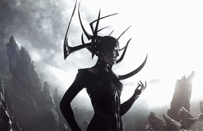 A Woman With Horns On Her Head Stands In Front Of A Mountain GIF