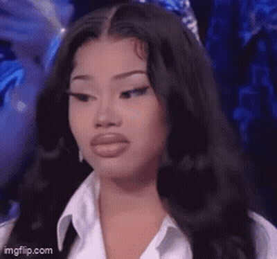 A Woman With Long Black Hair And A White Shirt Is Looking At The Camera . GIF
