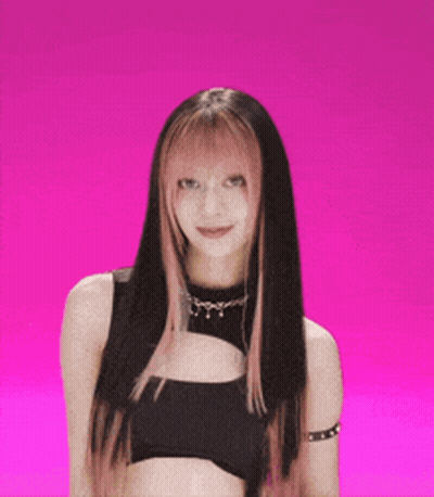 A Woman With Long Black Hair And Pink Highlights Is Wearing A Black Top GIF