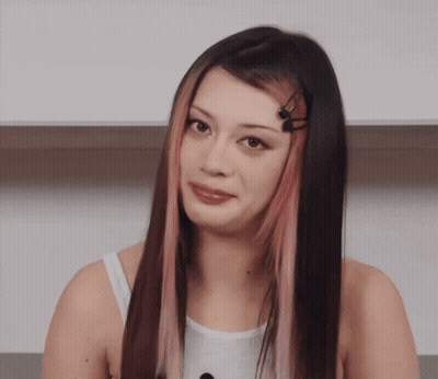 A Woman With Long Black Hair And Pink Streaks GIF