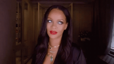 A Woman With Long Black Hair And Red Lipstick Is Wearing A Black Robe And Necklace . GIF