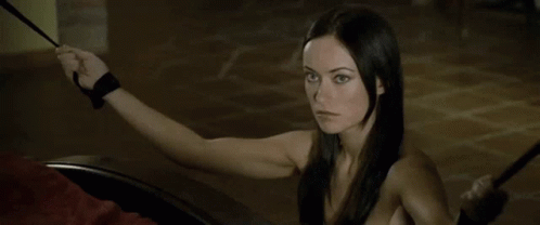 A Woman With Long Black Hair Is Holding A Whip In Her Hand . GIF