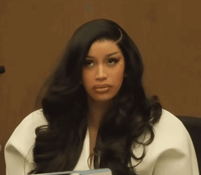 A Woman With Long Black Hair Is Sitting In A Courtroom . GIF