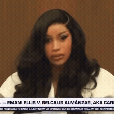 A Woman With Long Black Hair Is Sitting In Front Of A News Anchor . GIF