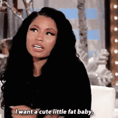 A Woman With Long Black Hair Is Sitting On A Couch And Talking . GIF