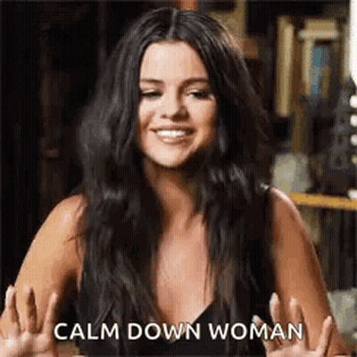 A Woman With Long Black Hair Is Smiling And Giving A Peace Sign . GIF