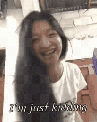 A Woman With Long Black Hair Is Smiling And Says I 'M Just Kidding GIF
