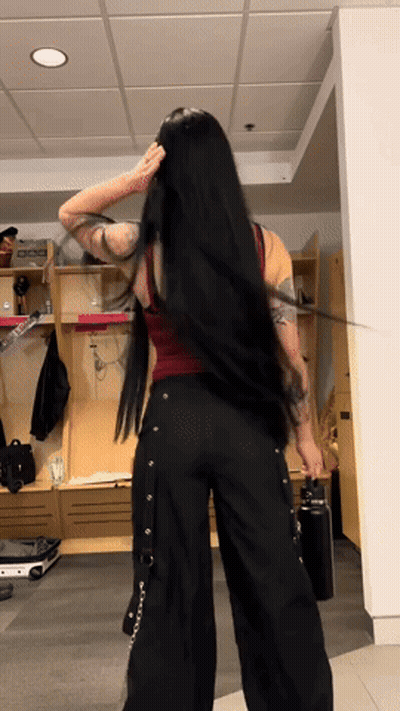 A Woman With Long Black Hair Is Standing In Front Of A Locker That Says Dog On It GIF