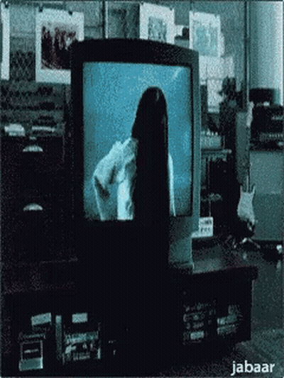 A Woman With Long Black Hair Is Standing In Front Of A Television Screen . GIF