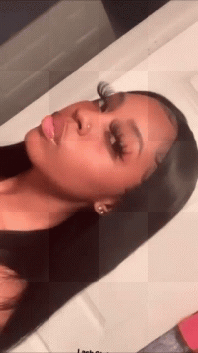 A Woman With Long Black Hair Is Taking A Selfie In A Mirror . GIF