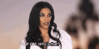 A Woman With Long Black Hair Is Talking To Another Woman While Wearing A White Shirt . GIF