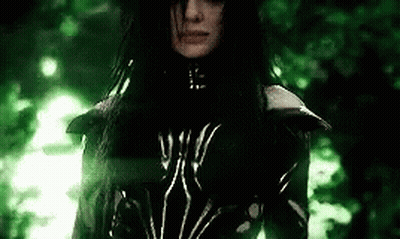 A Woman With Long Black Hair Is Wearing A Black And White Outfit . GIF