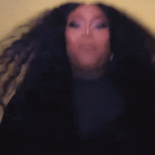 A Woman With Long Black Hair Is Wearing A Black Shirt GIF