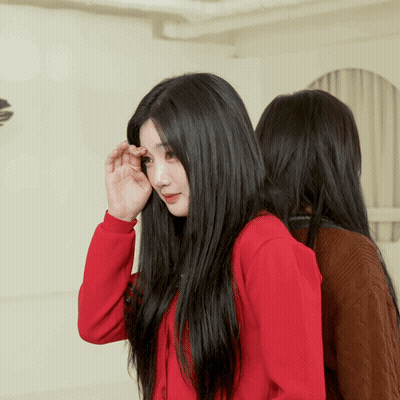 A Woman With Long Black Hair Is Wearing A Red Jacket GIF