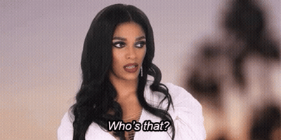 A Woman With Long Black Hair Is Wearing A White Shirt And Says `` Who 'S That '' . GIF