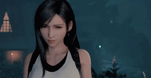 A Woman With Long Black Hair Is Wearing A White Tank Top With A Black Strap Around Her Neck GIF